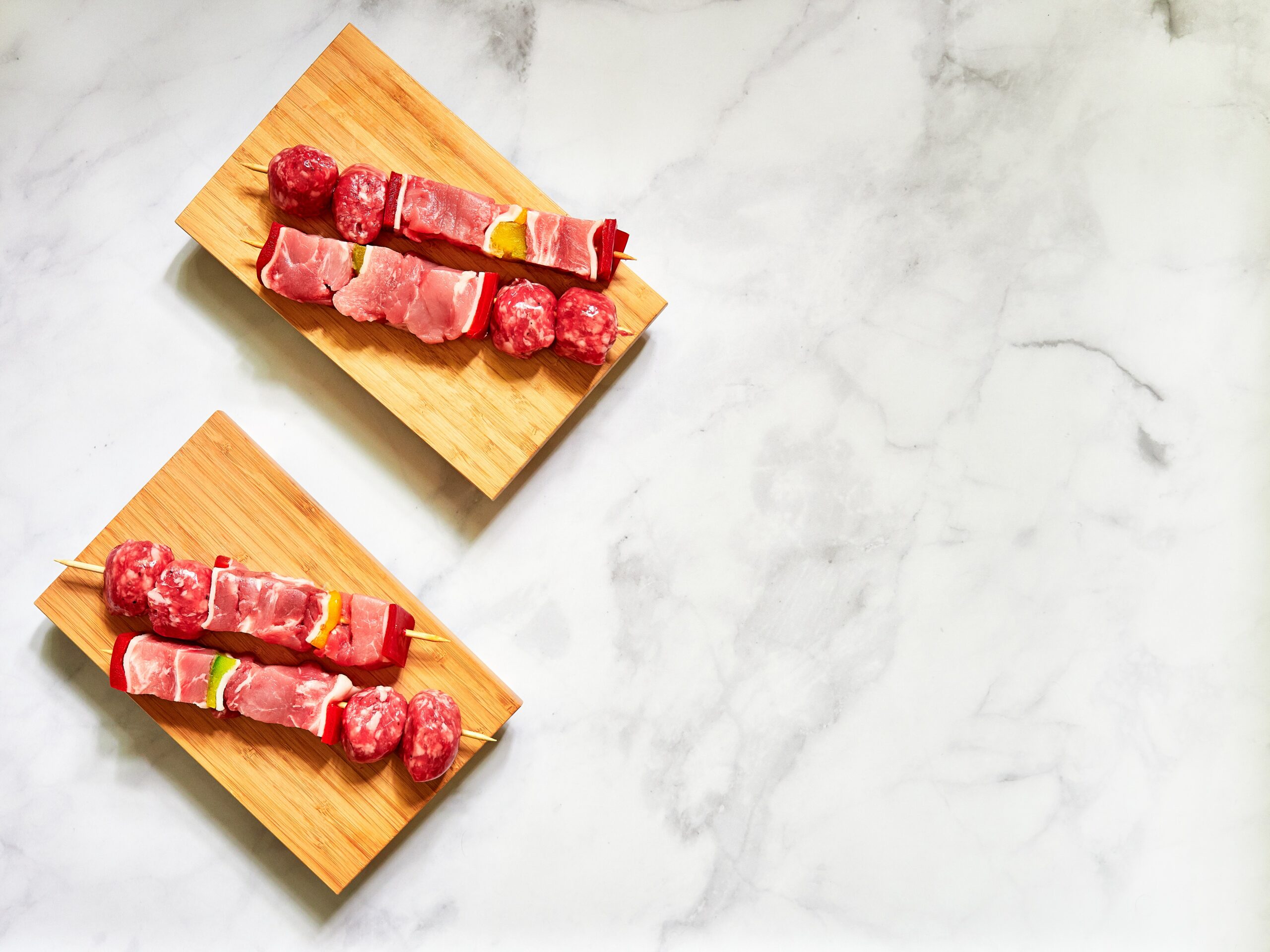 picture of raw meat skewers on board on top of marble slab
