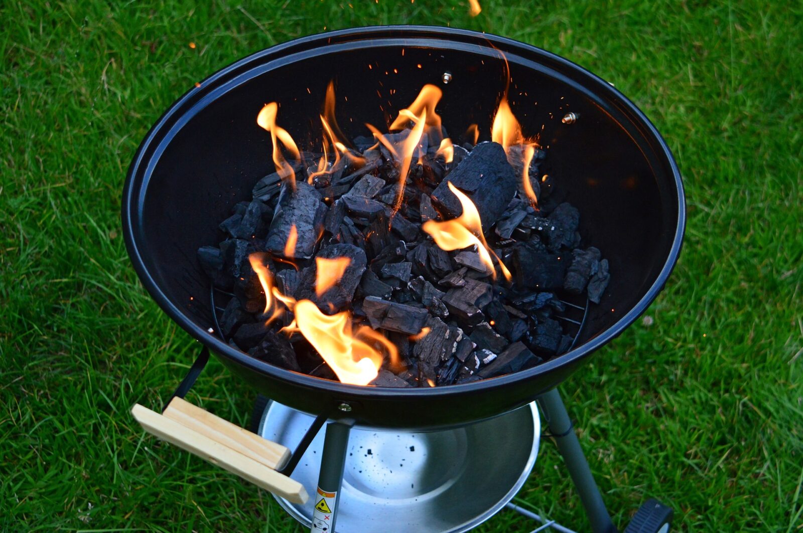 picture of charcoal smoker outside with lit flame